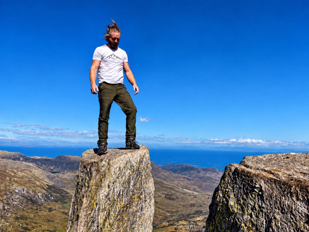 Climber wearing an Amor Montis T-shirt on a mountain summit